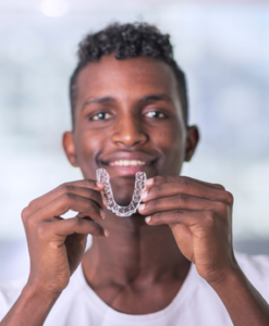 Man Holding Invisalign Aligners